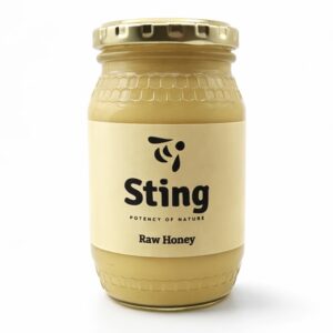 Jar of Sting Raw Honey with a gold lid and beige label reading 'Sting' and 'Raw Honey' against a white background, honey-colored glass jar.